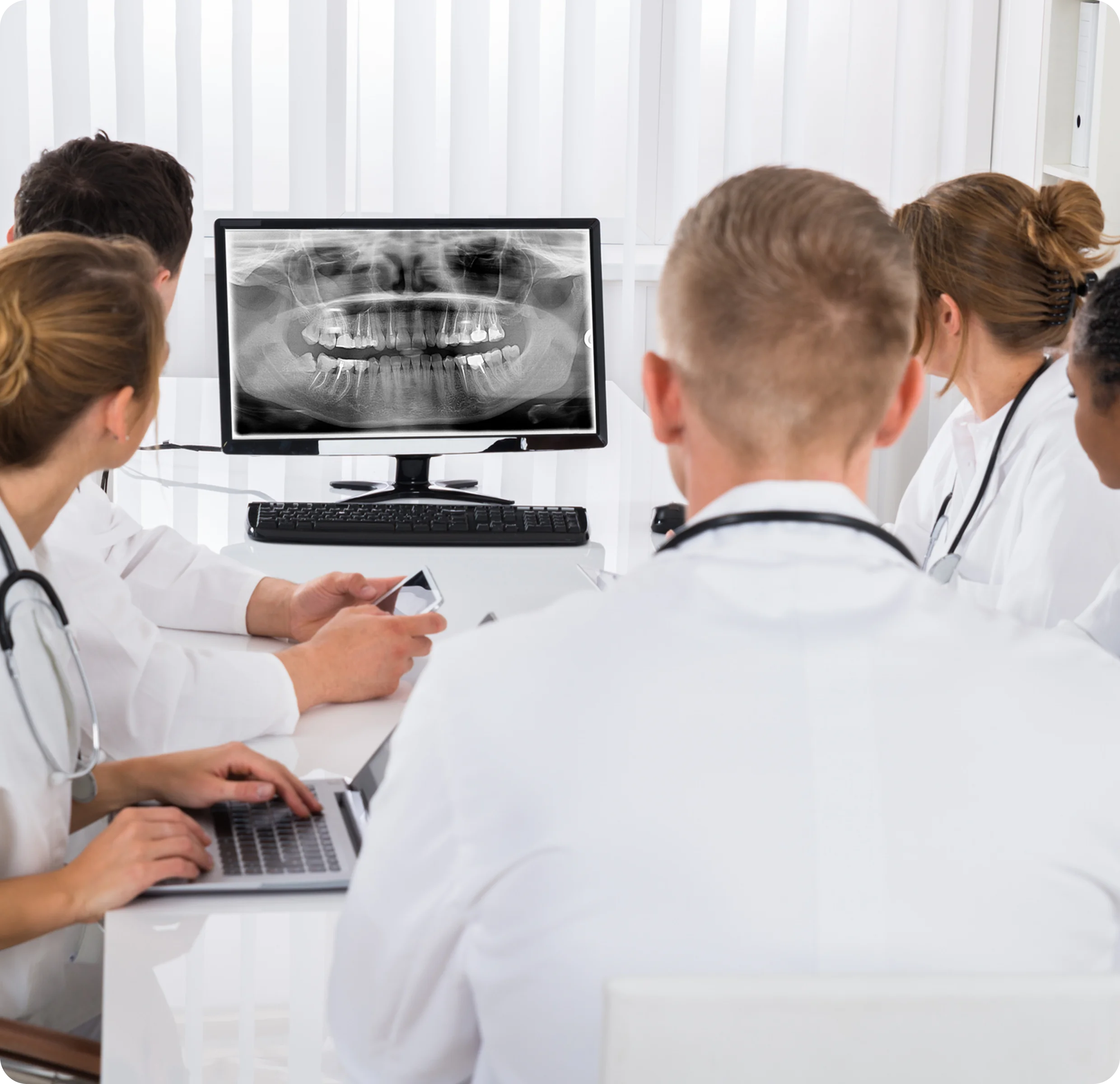 Doctors analyzing dental X-ray on computer.