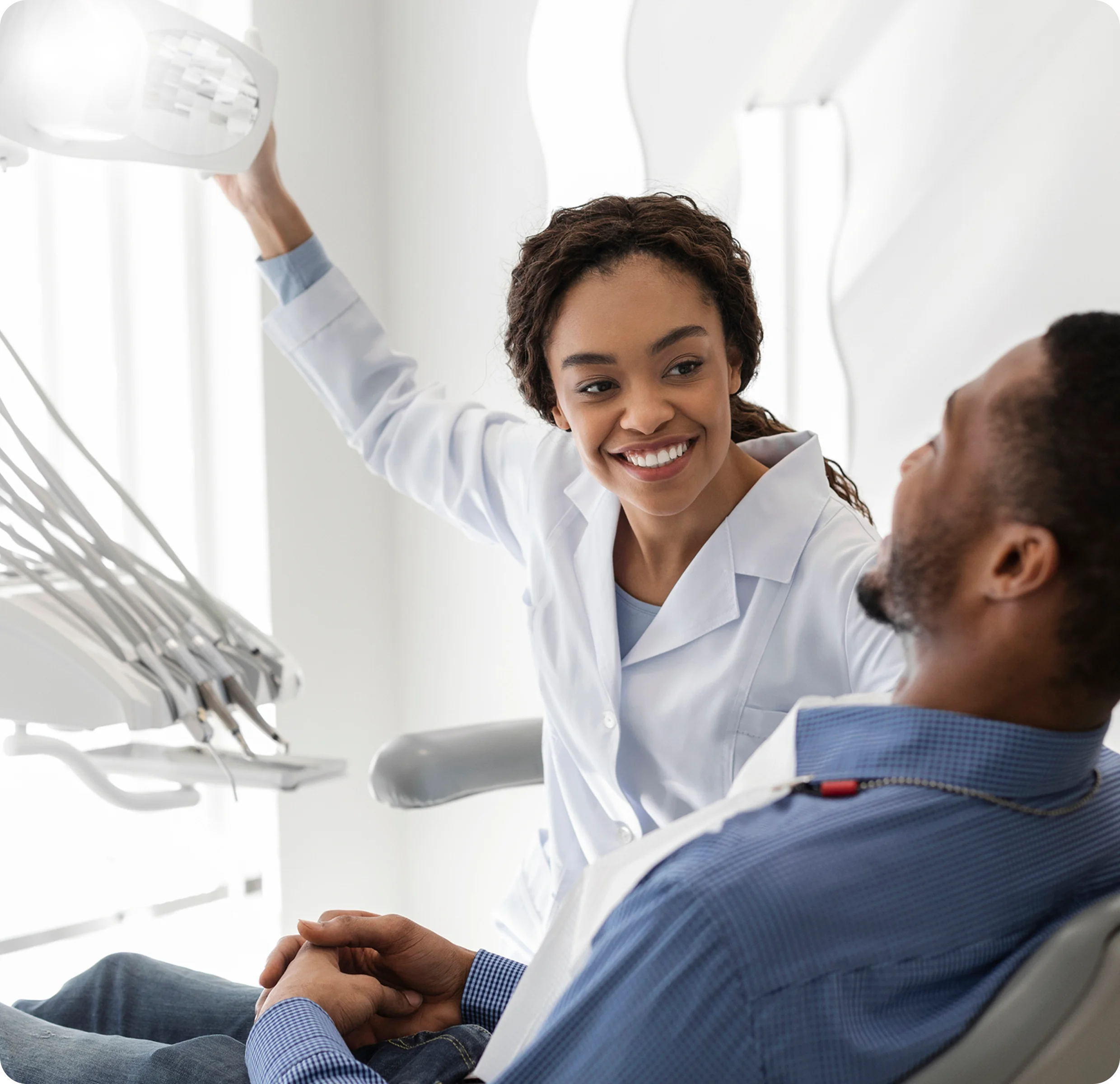 Dentist smiling at patient in dental office.
